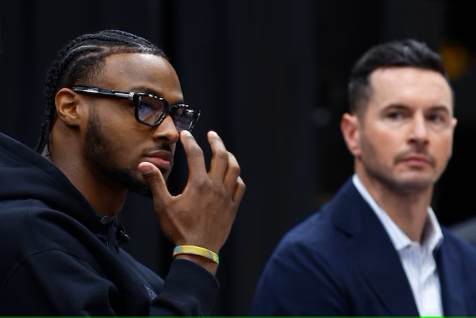 With Lakers Coach JJ Redick looking on Bronny James listens to a question during a news conference Tuesday in El Segundo Calif